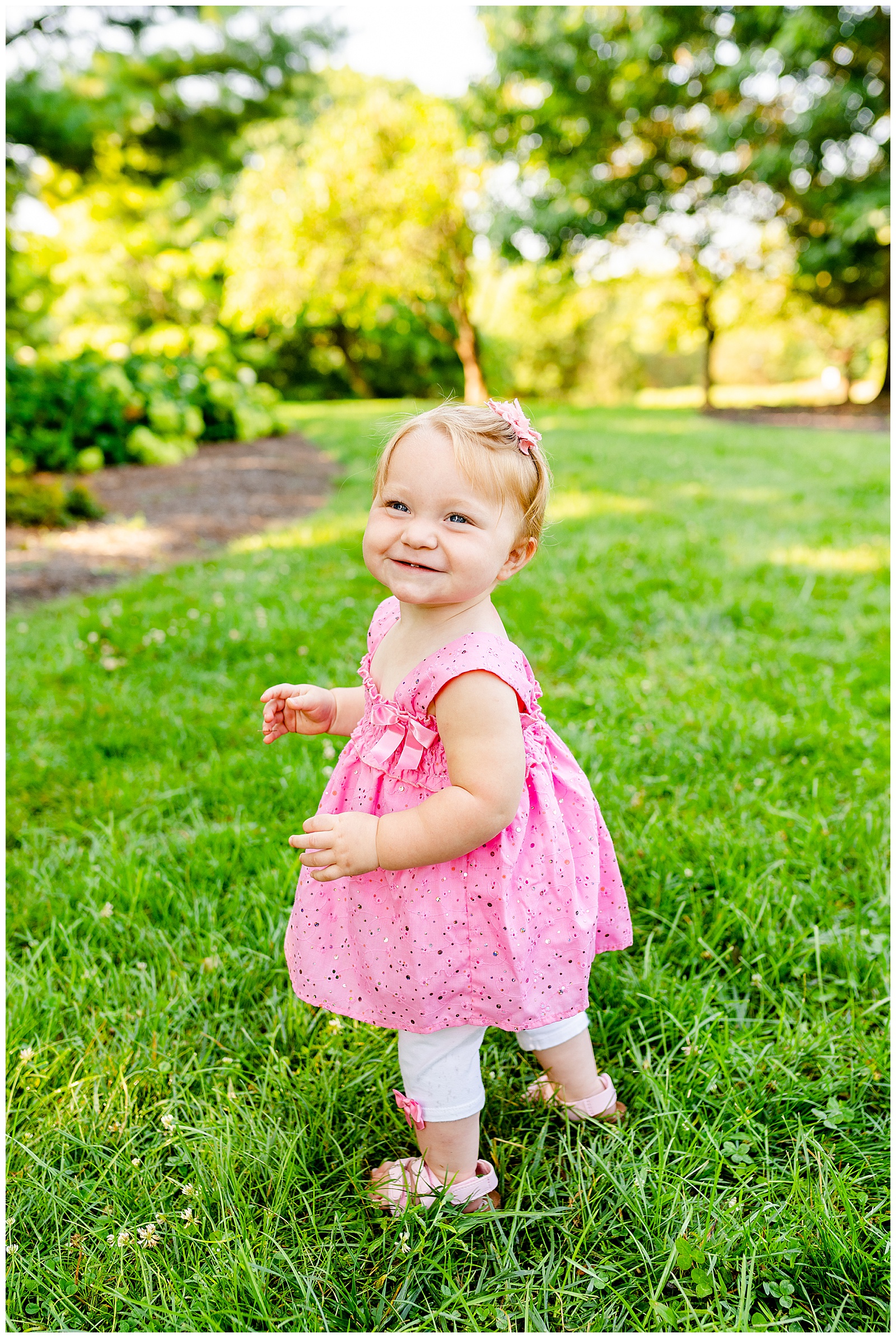 little girl in pink dress smiling at glenwood gardens