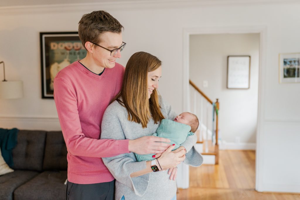 Family of 3 poses with their newborn in their Cincinnati home