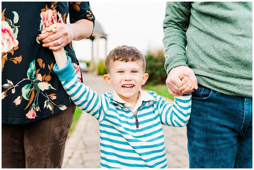 boy holding mom and dads hands